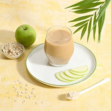 Herbalife Multi Fiber Drink in un bicchiere con fette di mela e avena su un piatto, per favorire l'assunzione di fibre e la digestione.